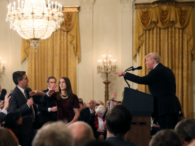   A White House staff member approaches the microphone held by CNN's Jim Acosta while questioning Donald Trump. Reuters 